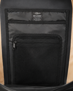 Close-up of the interior of a backpack showing a black mesh zippered pocket and a black fabric organizer panel with a visible Fjørør 'DRY x CORE' label.