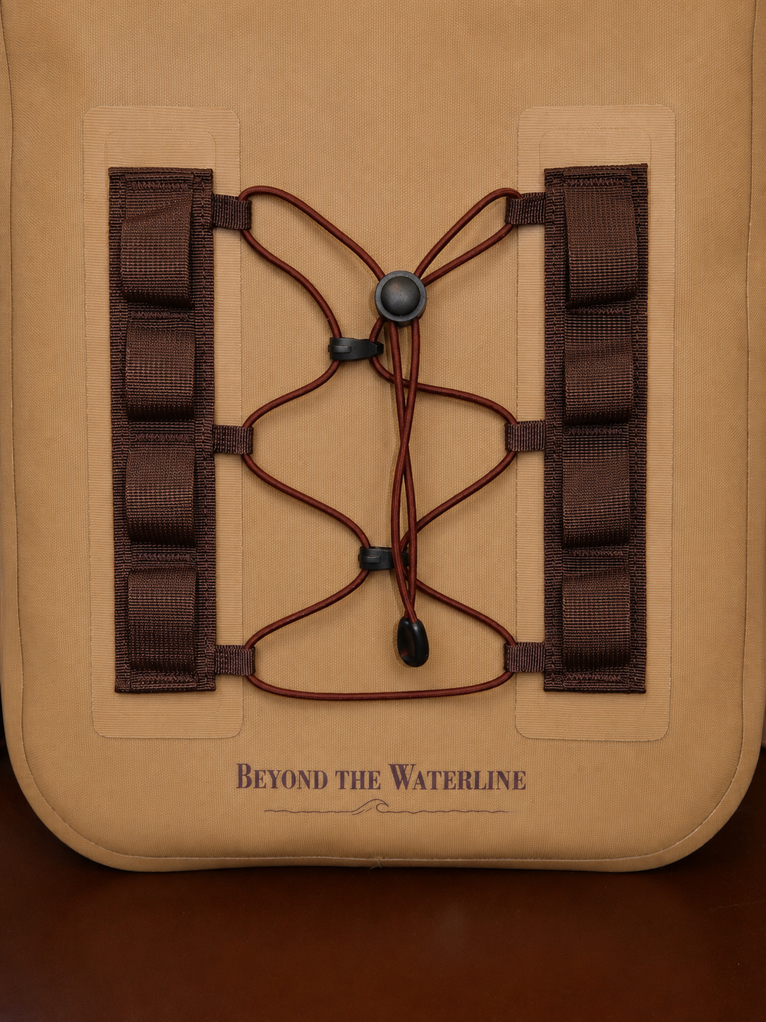 Close-up of a tan tactical pouch or bag with dark brown lacing and webbing straps, featuring the printed brand name 'BEYOND THE WATERLINE' near the bottom.